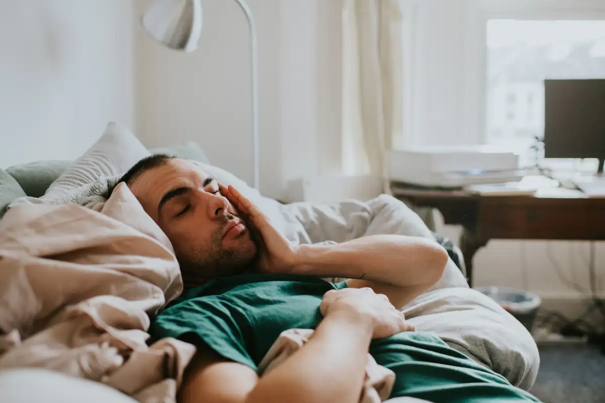 man using daylight lamp hotel room exhausted jetlag