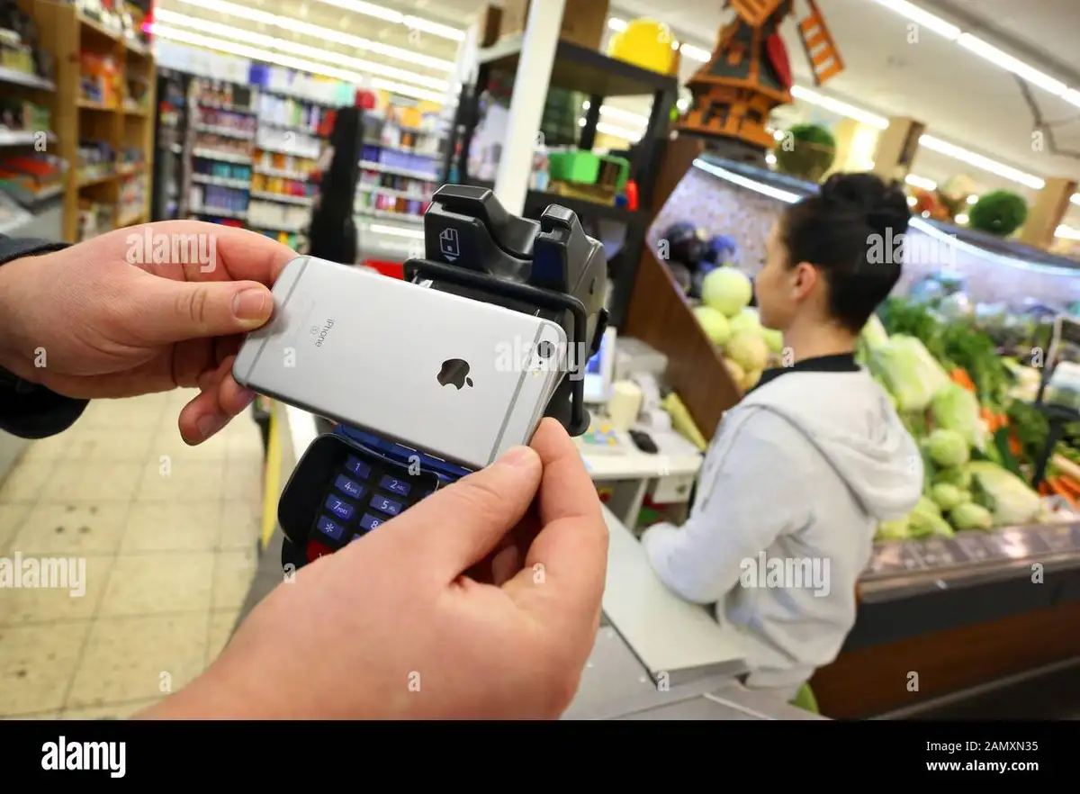 german people using smartphone to pay in supermarket