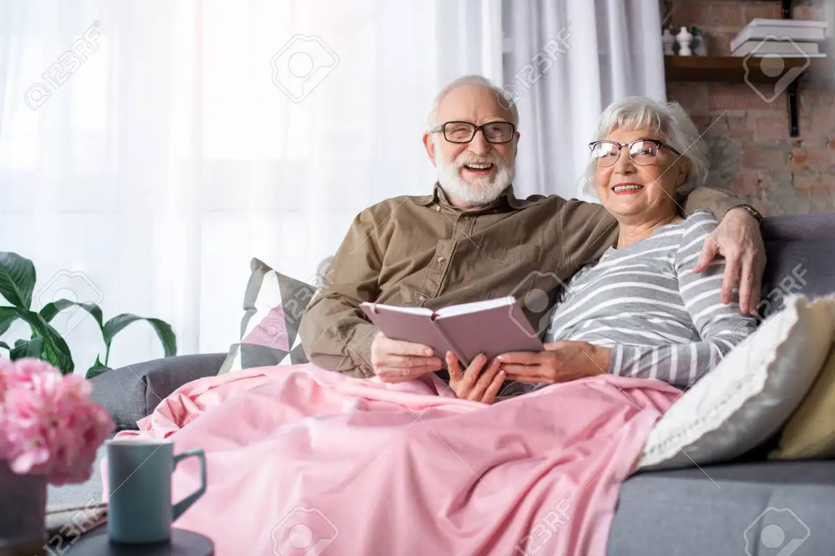 older couple cuddling on sofa cozy home germany