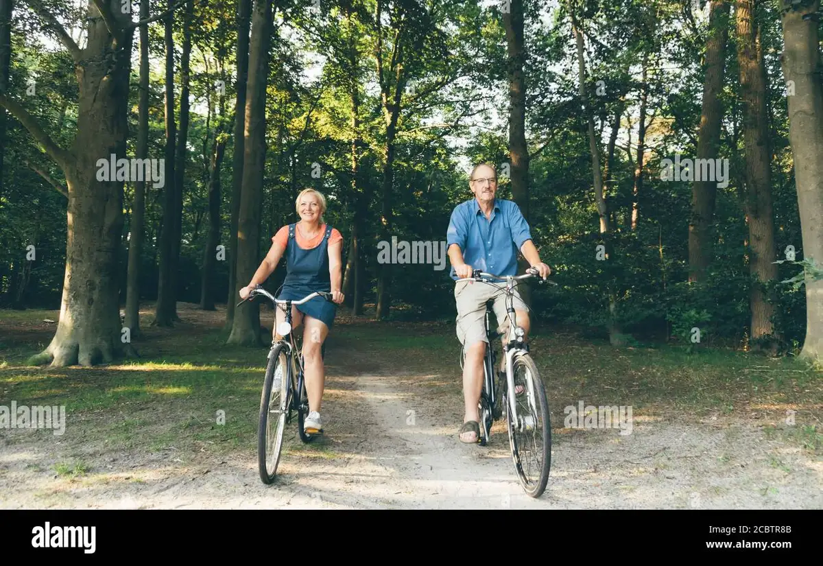 elderly couple cycling countryside smile healthy lifestyle