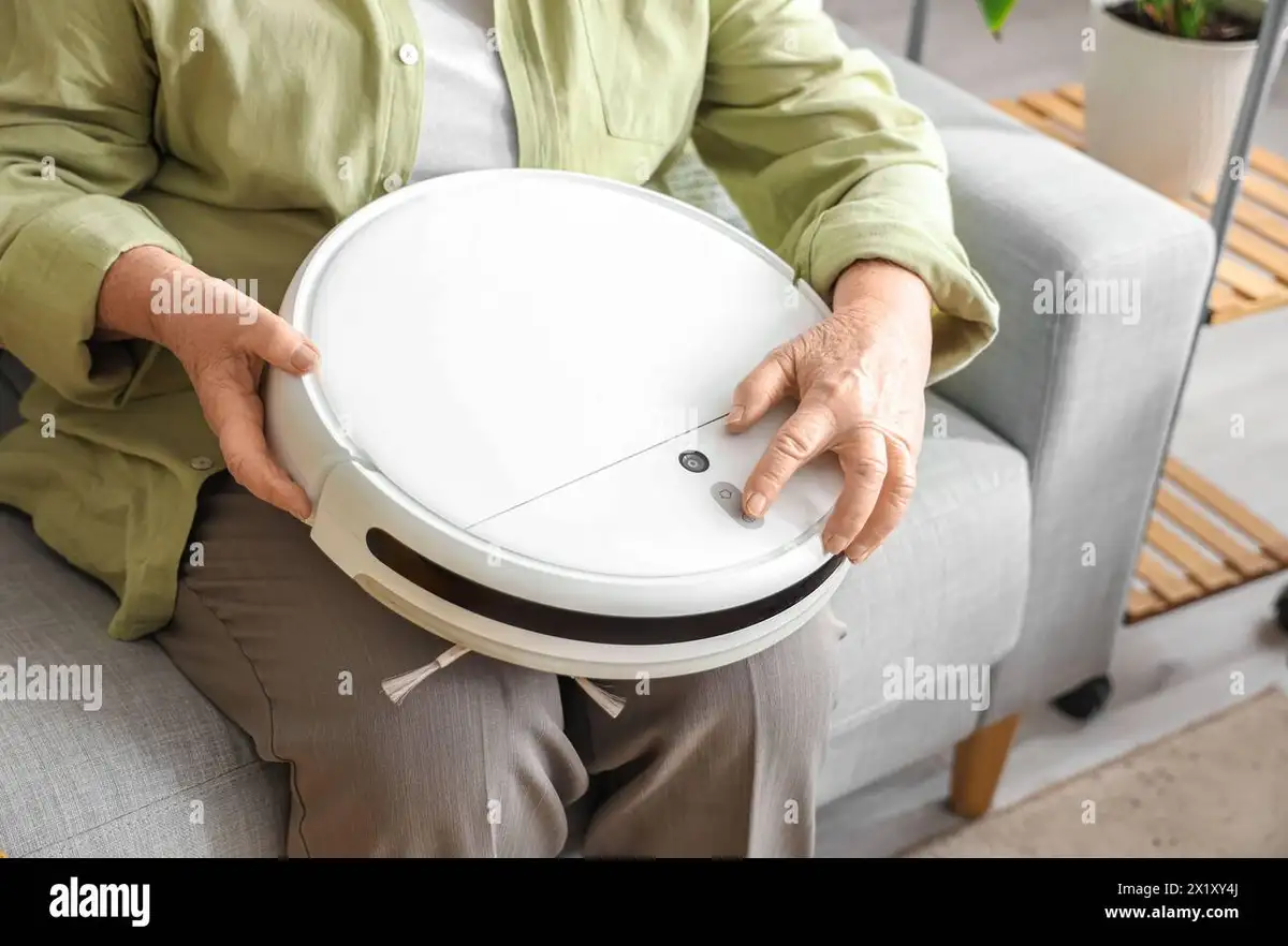 senior using robot vacuum in cozy living room