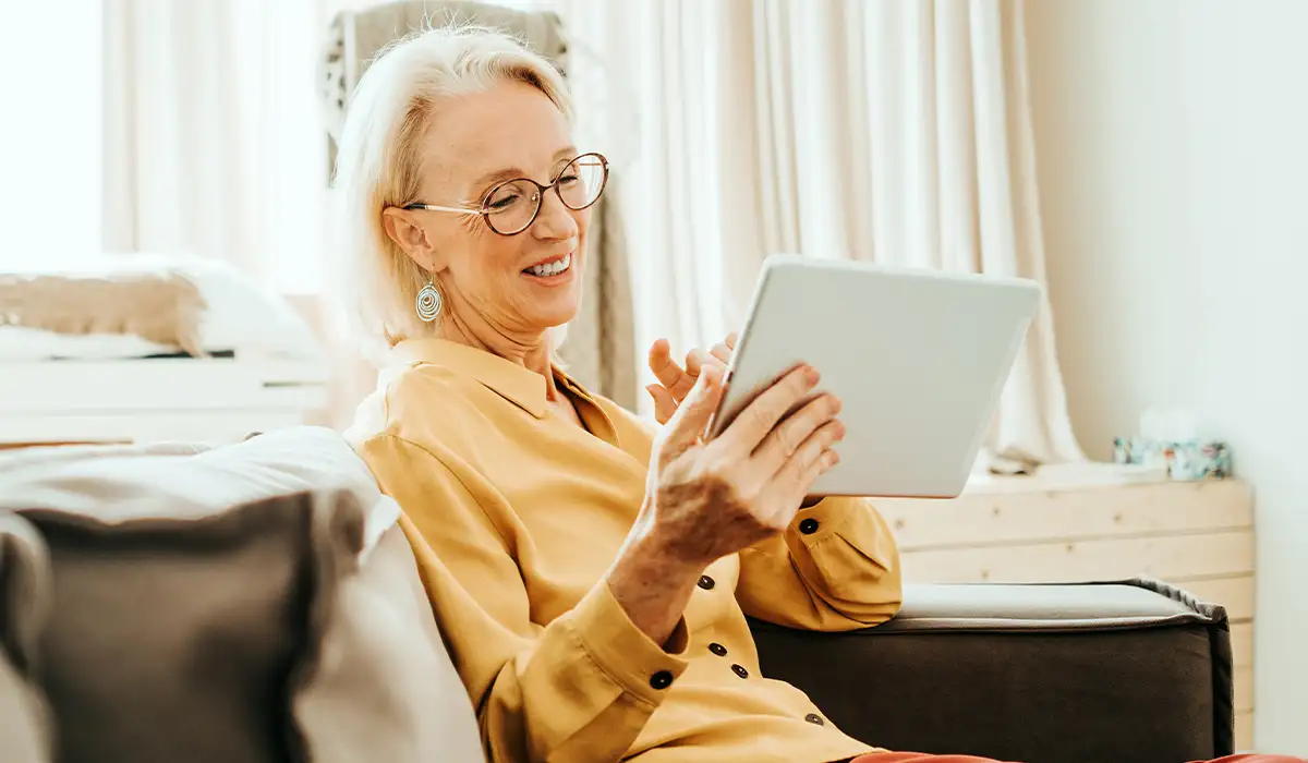 senior woman wearing assister smart band inside her home living room