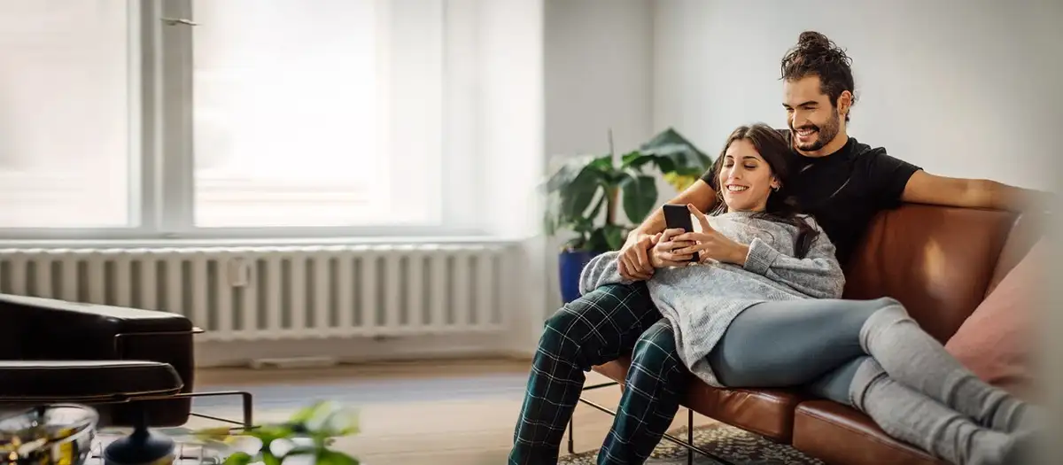 german young couple using banking app on smartphone home