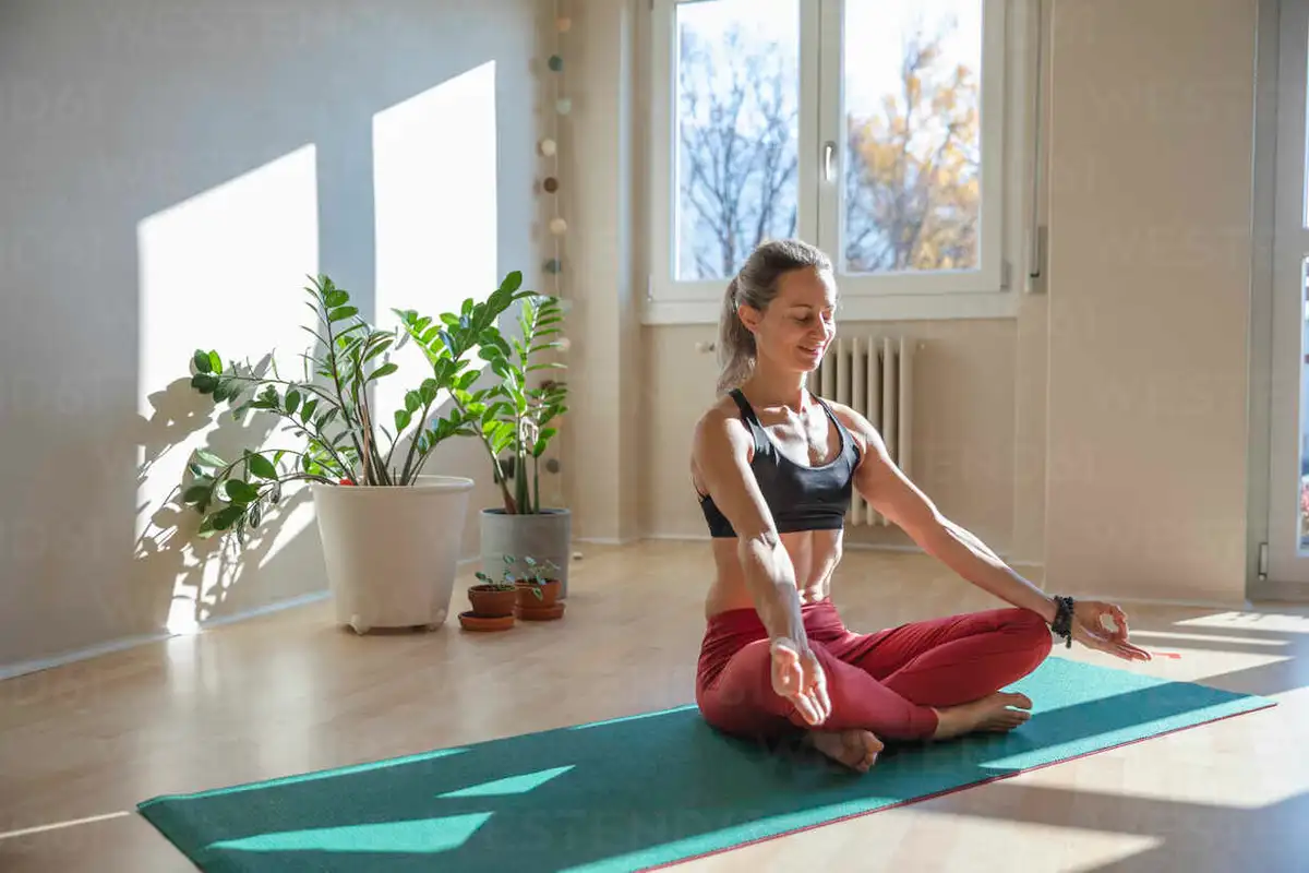 smiling senior woman doing yoga at home sunny